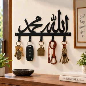 Home – Real Designs Islamic metal key holder with Allah and Muhammad Arabic calligraphy in black, mounted on a wall with keys hanging from its hooks