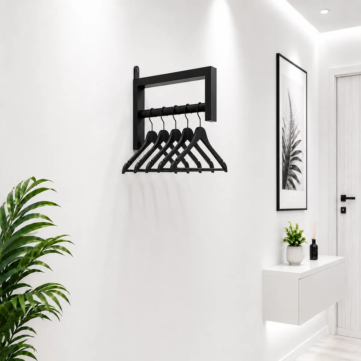 Wall Mounted Metal Clothes Hanger Rack with black hangers Black wall mounted metal clothes hanger rack with five black hangers on a white wall