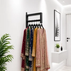 Home – Real Designs Black wall mounted metal clothes hanger rack holding embroidered dresses on a white wall